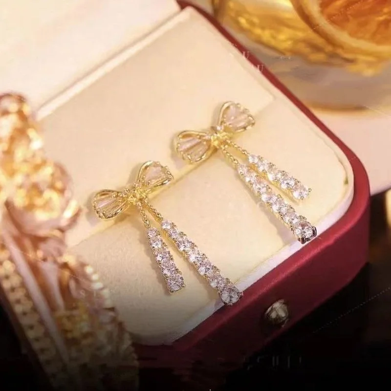 Orecchini pendenti con fiocco di temperamento per le donne Orecchini lunghi con strass lucidi color oro chic Gioielli alla moda