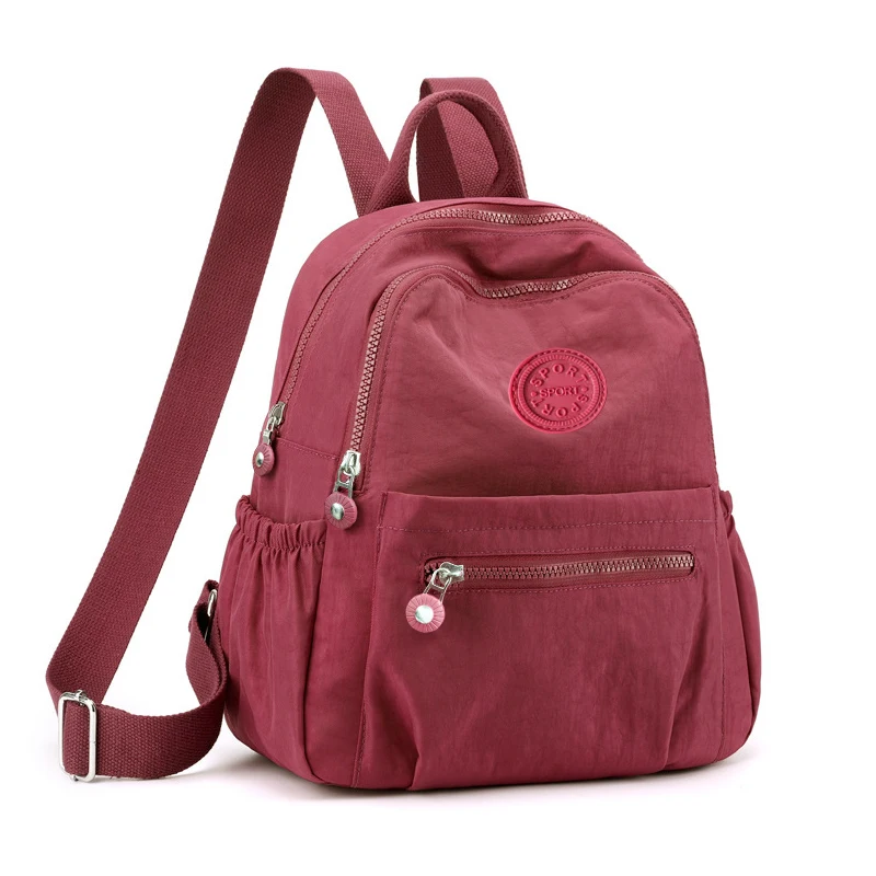Neutral Style Backpack for Men and Women, Suitable for Travel and Photography Made of Nylon Material, with a Round Logo Design.