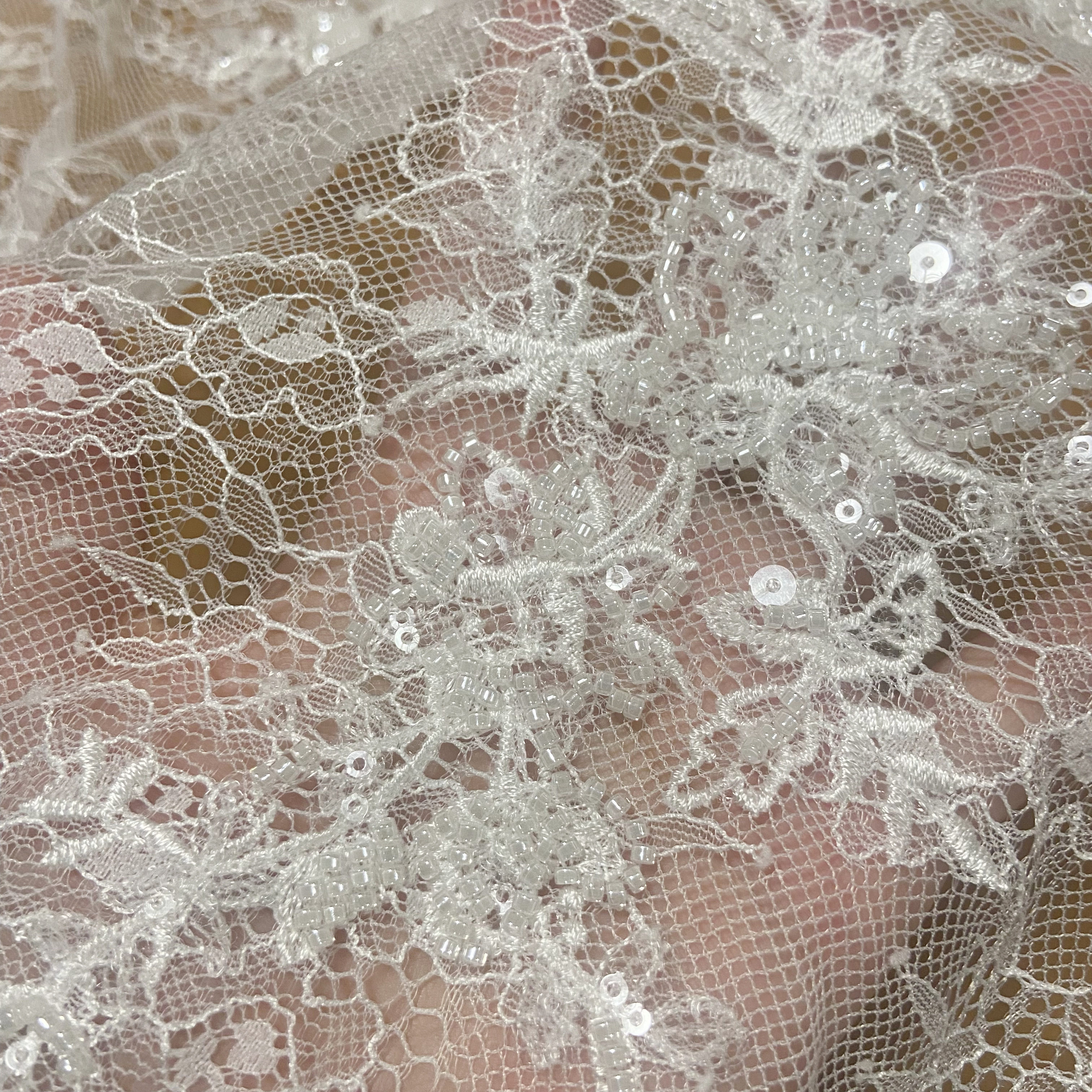 Las nuevas flores aberturas en la tela de encaje del vestido de cuentas de uñas
