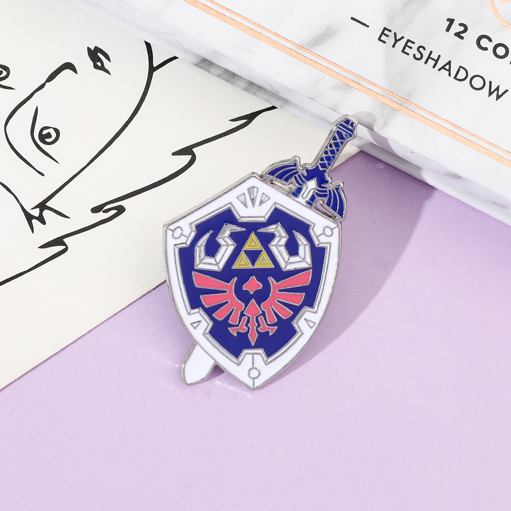 Juego creativo de dibujos animados que rodea la insignia de Metal Legend Of Zelda escudo espada personalidad aleación gota de aceite broche
