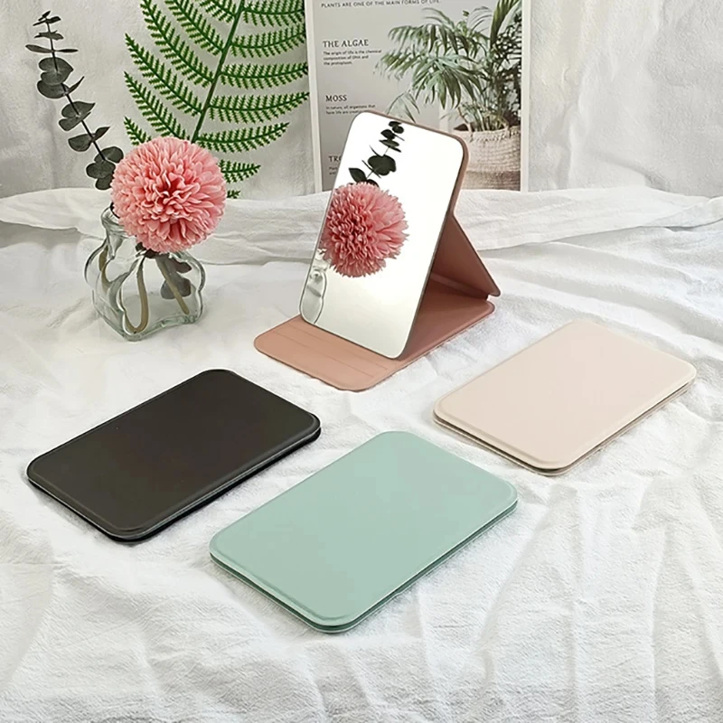 MINI espejo de maquillaje plegable para mujer, espejo de maquillaje de bolsillo portátil de alta calidad, escritorio creativo de un solo lado con mango de Color sólido para mujer
