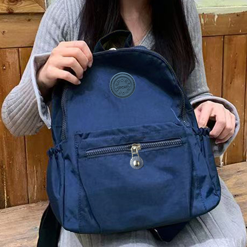 Neutral Style Backpack for Men and Women, Suitable for Travel and Photography Made of Nylon Material, with a Round Logo Design.