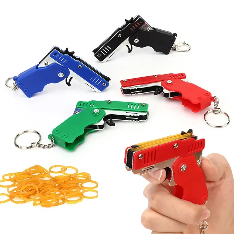 1PC Mini Portachiavi Pistola Elastico Pistola Pistola Giocattolo Pistola da tiro Lega Kid Attività all'aperto Gioco di società Regalo di compleanno per i bambini