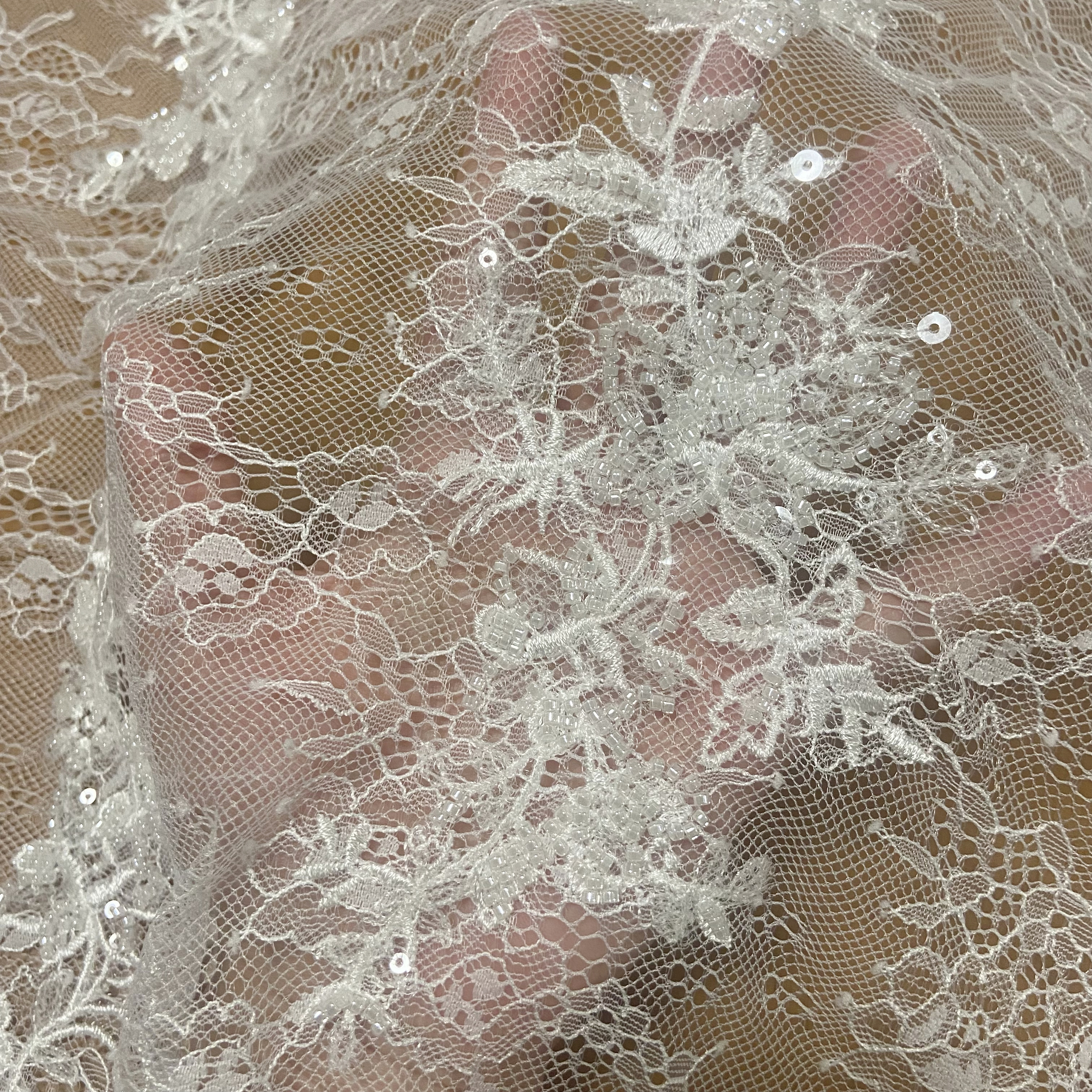 Las nuevas flores aberturas en la tela de encaje del vestido de cuentas de uñas