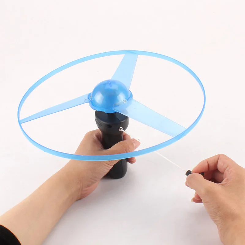 1PC LED Luminous Flying Disc Launcher แบบพกพาดึง String Flying Saucer กีฬากลางแจ้งเกมสําหรับเด็กของขวัญวันเกิด
