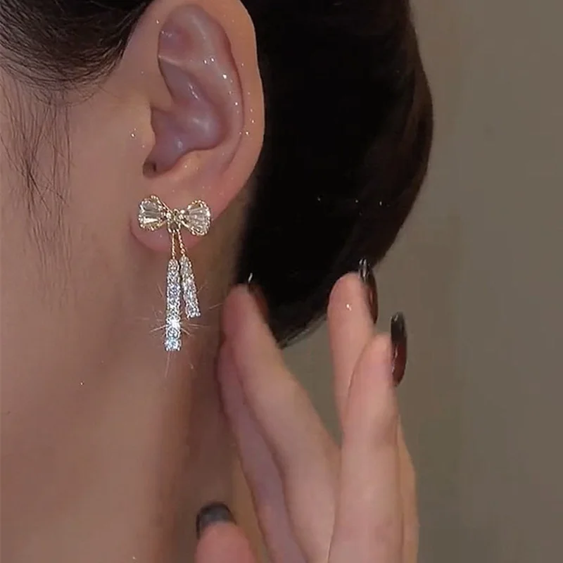 Orecchini pendenti con fiocco di temperamento per le donne Orecchini lunghi con strass lucidi color oro chic Gioielli alla moda