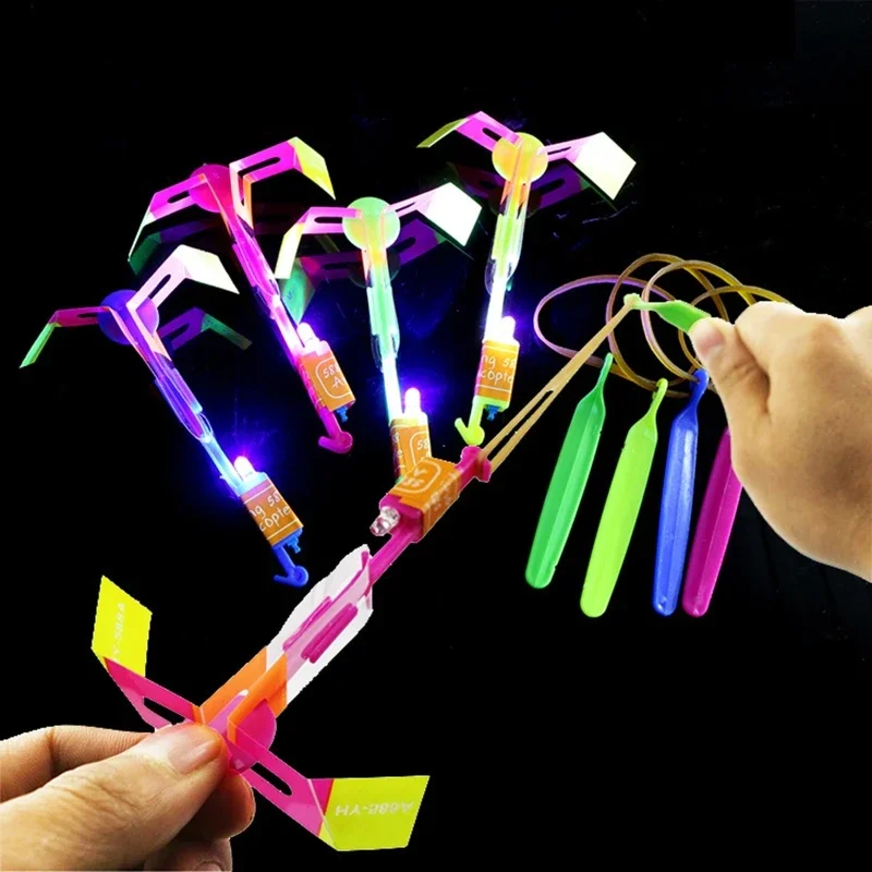 Divertido deporte al aire libre luz LED flecha cohete helicóptero tirachinas avión juguetes voladores banda de goma catapulta libélula de bambú regalo