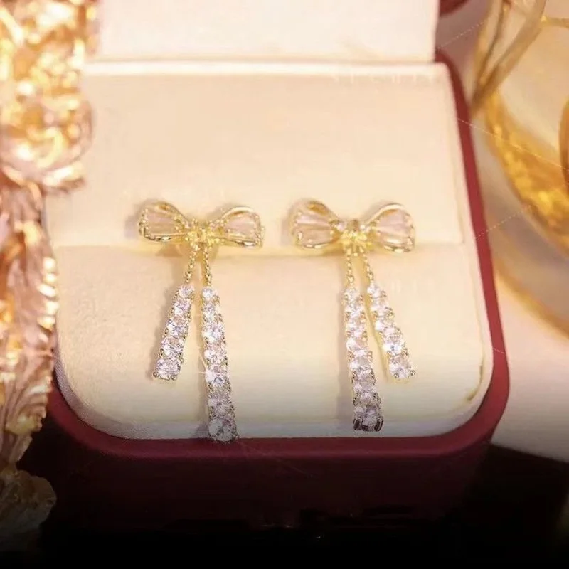 Orecchini pendenti con fiocco di temperamento per le donne Orecchini lunghi con strass lucidi color oro chic Gioielli alla moda
