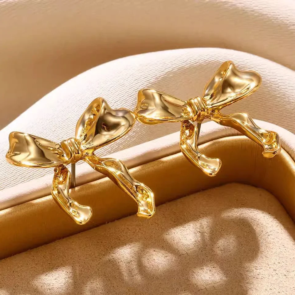 ZAKOL Orecchini con nodo a fiocco in nastro metallico color oro dolce per donne e ragazze Accessori per orecchie Y2K con fiocco irregolare