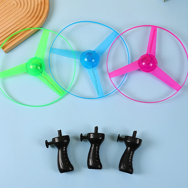 1PC LED Luminous Flying Disc Launcher แบบพกพาดึง String Flying Saucer กีฬากลางแจ้งเกมสําหรับเด็กของขวัญวันเกิด