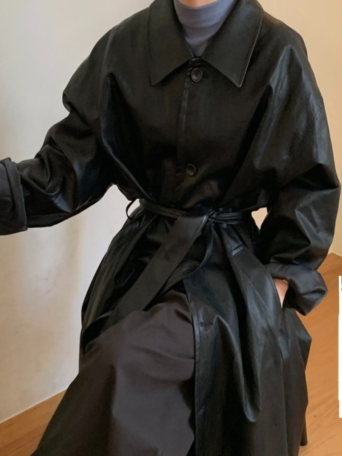 ロングレザージャケットの女性の秋のファッション香港スタイルのシックなレトロなラペルベルト付きウエスト黒のハイエンドの感触コート