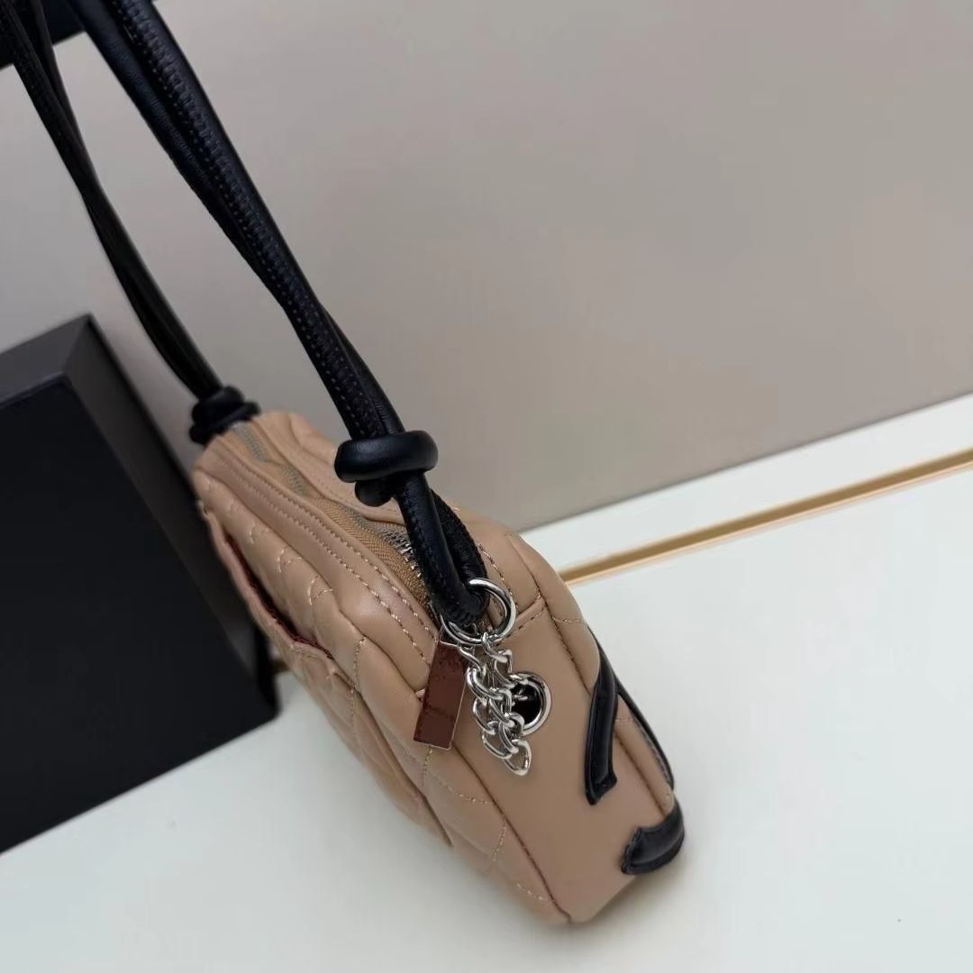 Sac matelassé bicolore beige et noir avec bandoulière en cuir noué et mini sac bandoulière zippé.