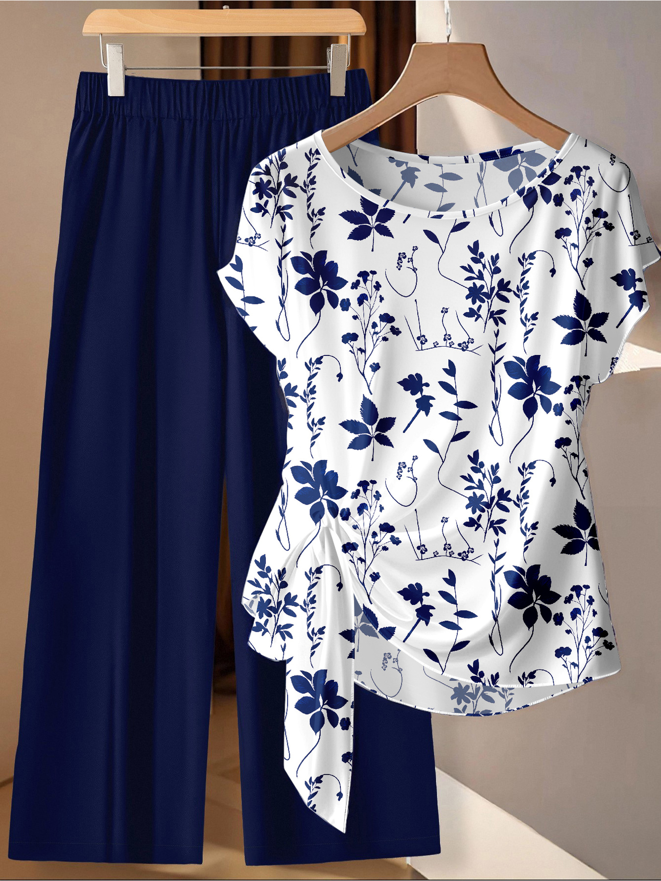 Sommerliches, bequemes und lässiges Damen-Set in Übergröße: Weißes Oberteil mit Pflanzenmuster und marineblaue Hose mit weitem Bein, zweiteiliges Set