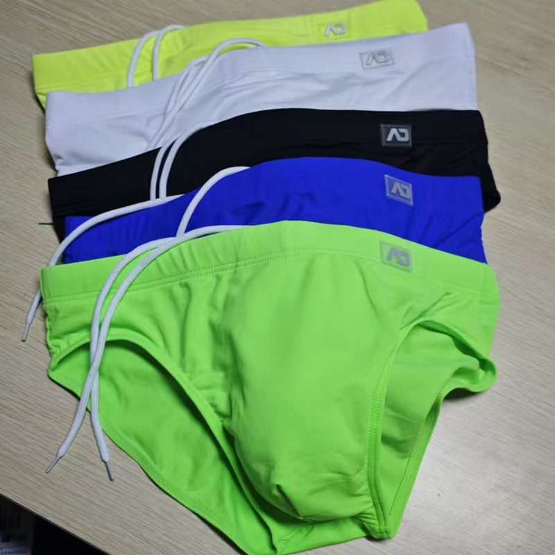 2026 Combina ropa interior masculina de cintura baja, bañadores de nailon de color liso, pantalones de playa con copa anti-embarrasamiento y cordón ajustable BS420