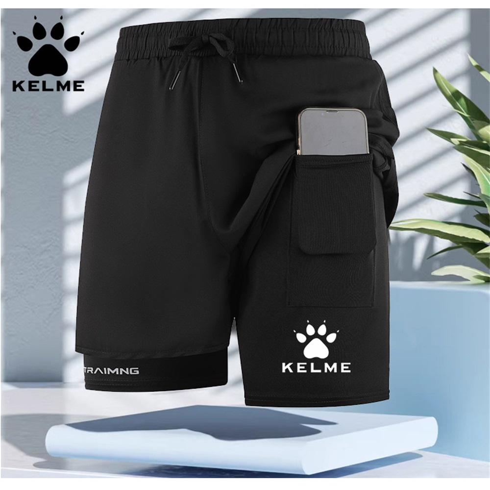 Celana pendek olahraga pria KELME berlapis ganda, dengan desain tali serut dan lapisan bernapas, cocok untuk lari dan kebugaran.