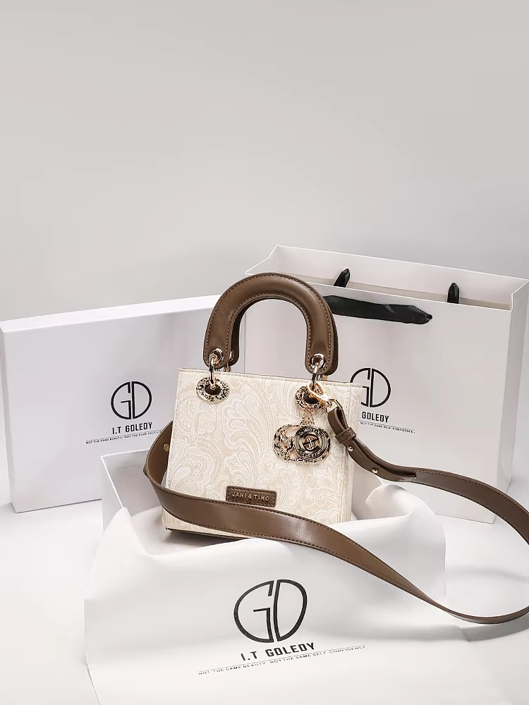 Luxuriöse und vielseitige quadratische Handtasche mit zarter Stickerei und hochwertigem Metallanhänger. Neue modische Umhängetasche für Damen