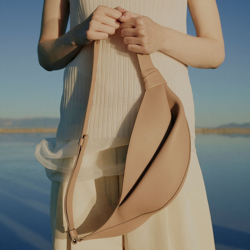 Nova bolsa transversal feminina de couro liso, moderna e versátil, estilo croissant.