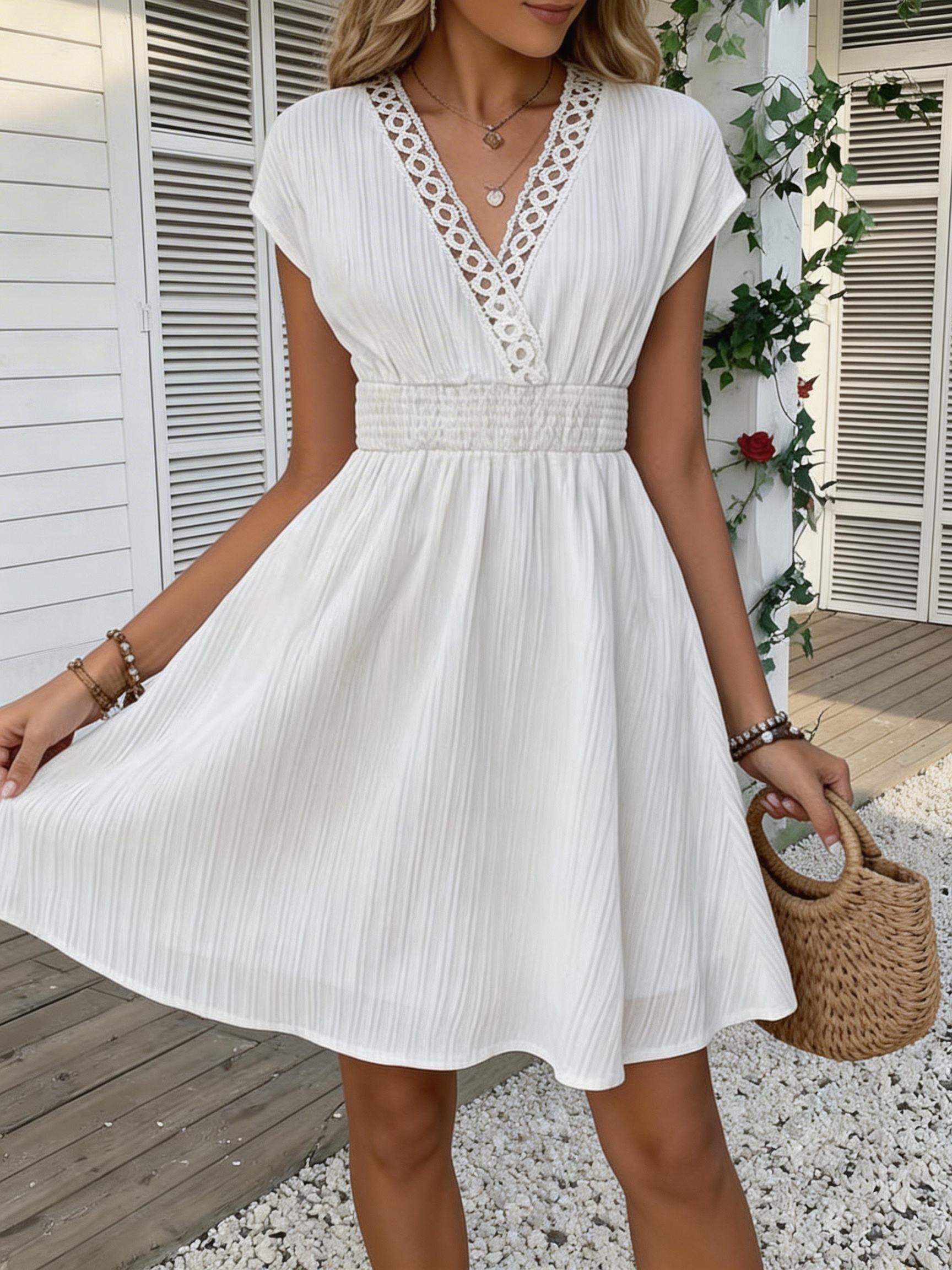 Vestido entallado con cuello en V de encaje francés, cintura definida y mangas cortas abullonadas. Falda corta con textura a rayas y líneas verticales. Beach-st